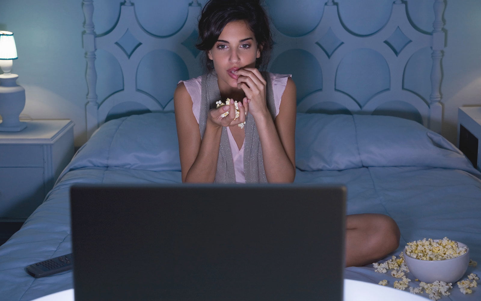 девушка перед экраном смотрит кино в онлайн-кинотеатре
